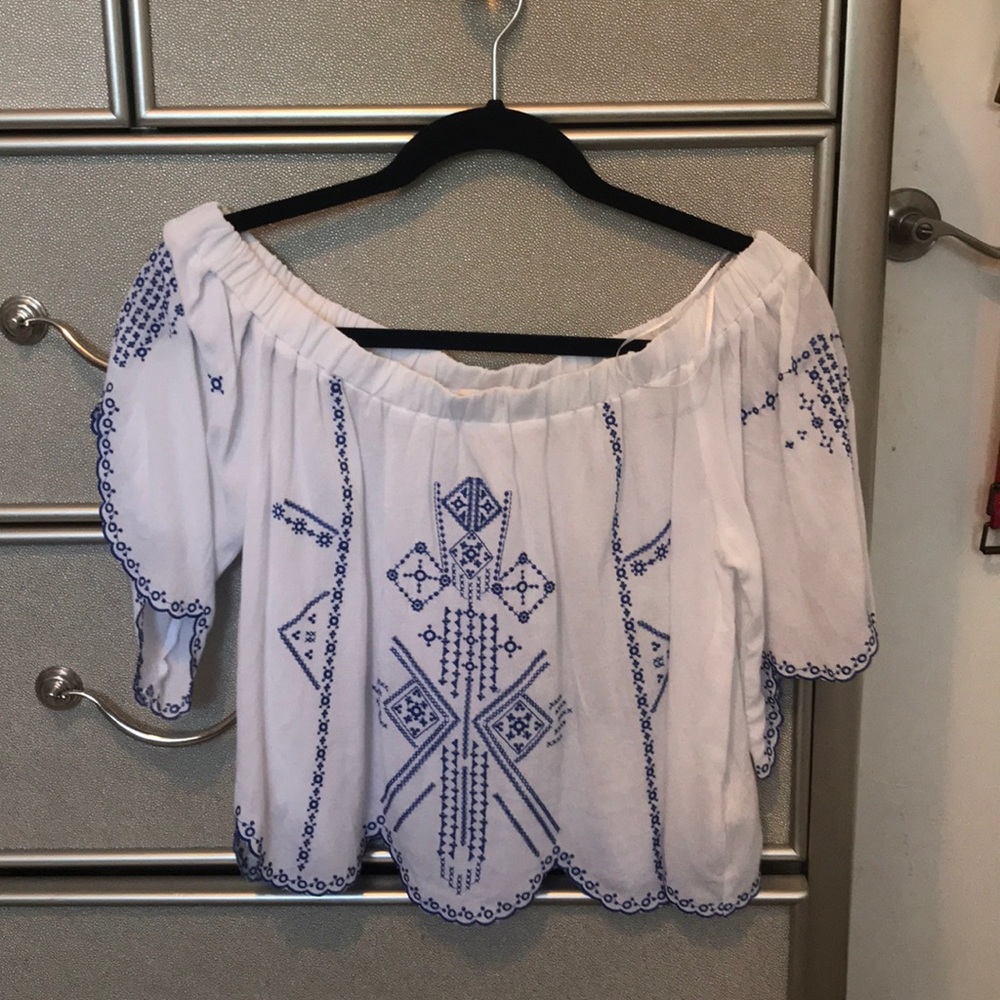 Off the shoulder white and blue design shirt.